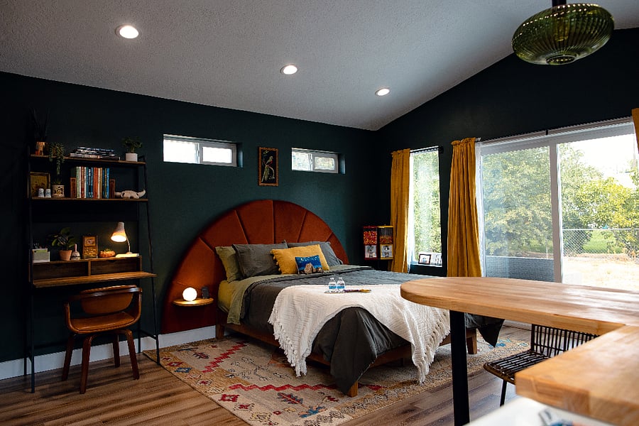 The backyard unit's bed, work area, and eat-in kitchen island.