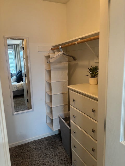 Walk In Closet has dresser for all your things along with a laundry basket, hangers, and mirror for your convenience. 