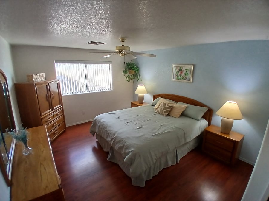 Spacious bedroom features California king bed and plenty of storage space. Electric security shutter covers window for blackout sleeping.