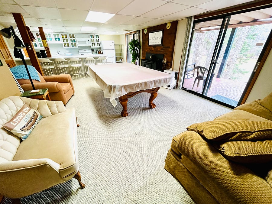 Large great room with pool table that can convert to ping pong table, a dining bar, and fully stocked kitchen with gorgeous lake views out the 2 sliding glass doors. 