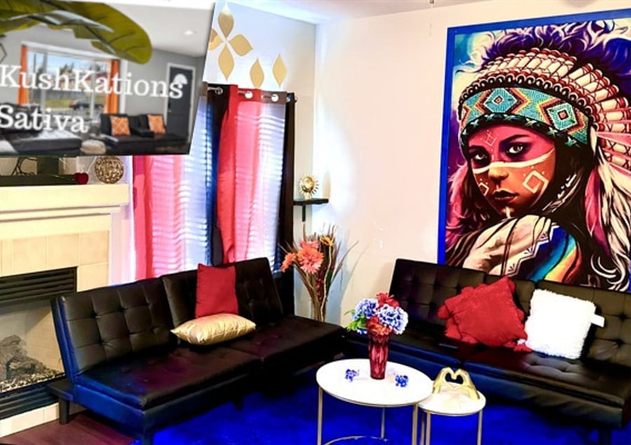 The living room is colorful with a striking mural, black sofas, a blue rug, and a fireplace. A hanging chair and red curtains add to the decor, while a small table with vases and a metal wall