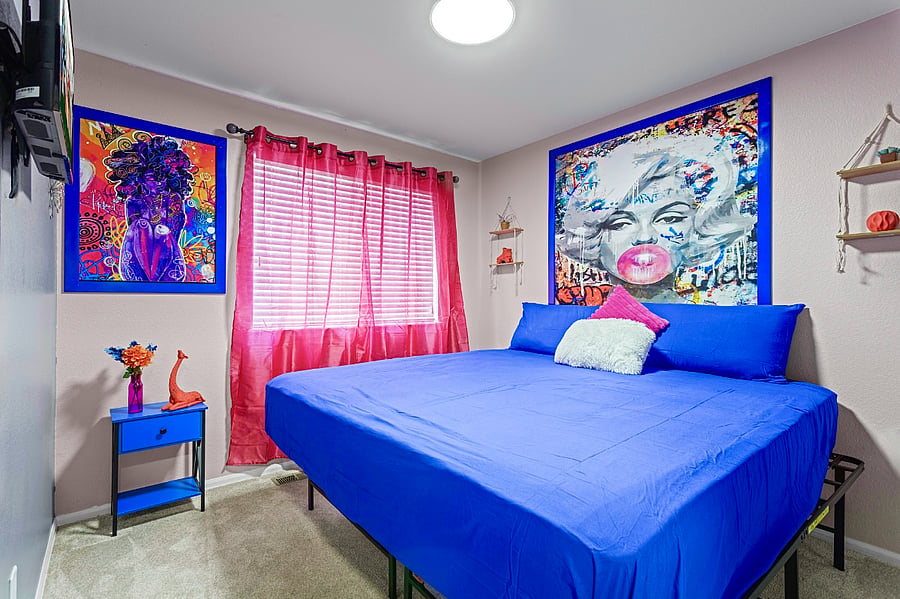 Bright and airy bedroom with a comfortable king-size bed and colorful decor. Perfect for a restful night's sleep.
