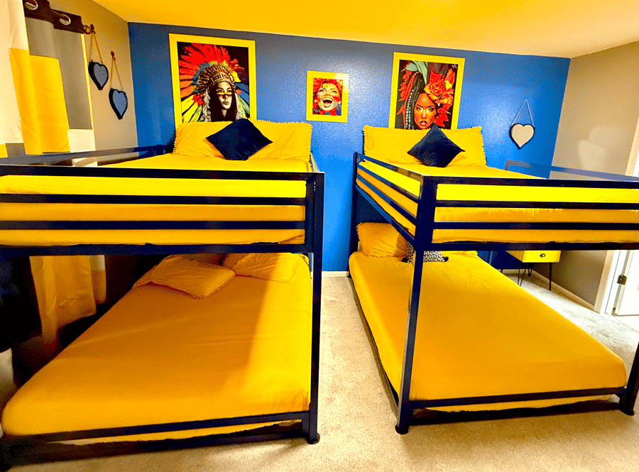 The bunk bedroom is a fun, functional space for kids and guests, featuring a cheerful yellow and blue color scheme with colorful artwork. The bunk beds maximize space and offer a cozy sleeping arrangement, creating more room for play and activities.