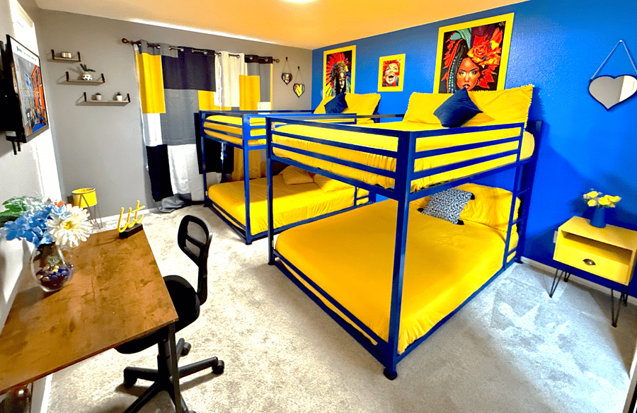 Showcasing the other side of the bedroom, which includes two bunk beds and a large window that allows plenty of natural light to fill the space.