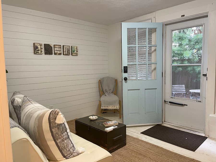 Ground floor, back door. Couch converts to a bed for guests. Half bathroom located on this floor