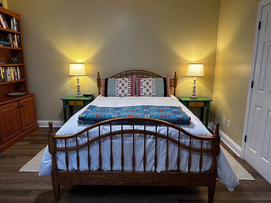 Second bedroom with hand painted side tables, and bookcase.