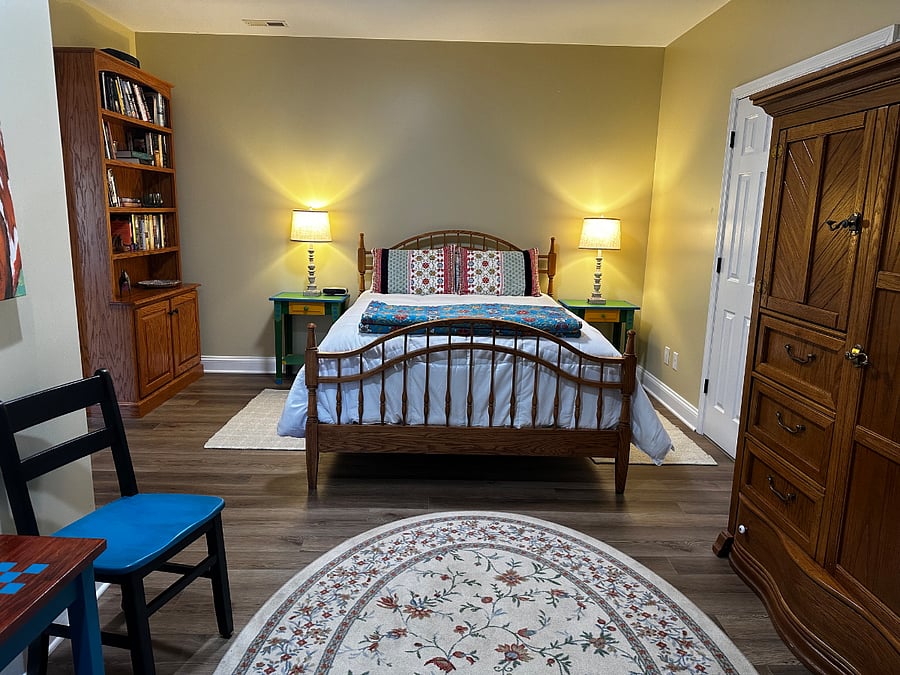 Second bedroom with armoire for lots of clothes, book case with reading material, side tables, and smart TV. This room is down a hallway open to the kitchen and living area. It includes a privacy screen. It also where the washer/dryer is accessed.