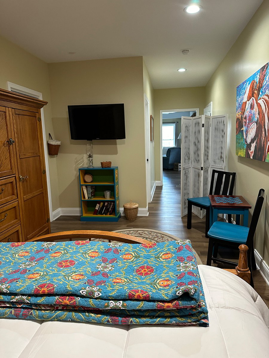 Second bedroom with checkers table, smart TV, and privacy screen. This room is down a short hallway and open to the kitchen and living room. It includes a privacy screen.