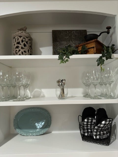 Wine glasses on shelf above sink.