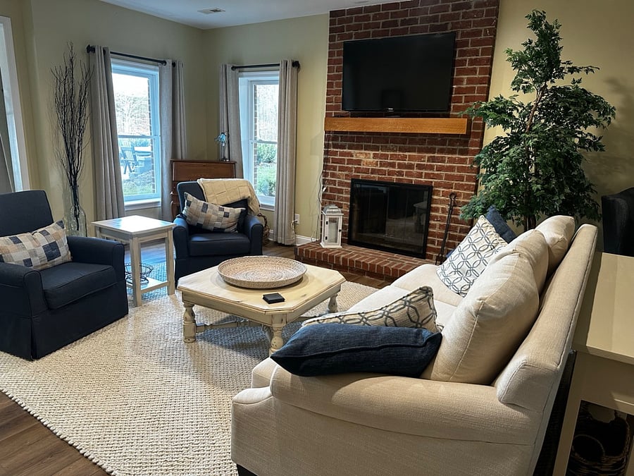 Master living area with fireplace, couch, swivel chairs, large coffee table, smart TV, and dedicated workspace.