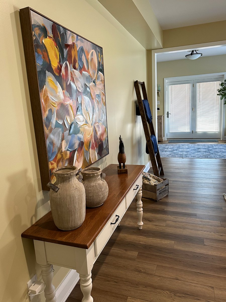 Art, console table, and orchard ladder in the master living area opposite the fireplace. The apartment has lap blankets for use outside when using the fire pit.