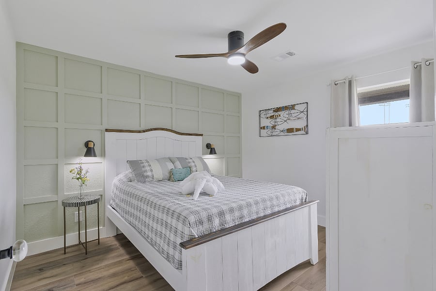 2nd guest bedroom with queen bed and walk in closet, ceiling fan, side tables, lamps and dresser on front of house.