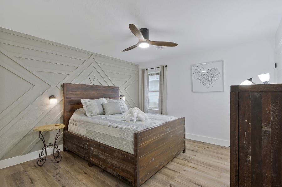 3rd guest bedroom with queen bed, ceiling fan, side tables, side lights, and dresser with walk in closet, on left side, center of the home.