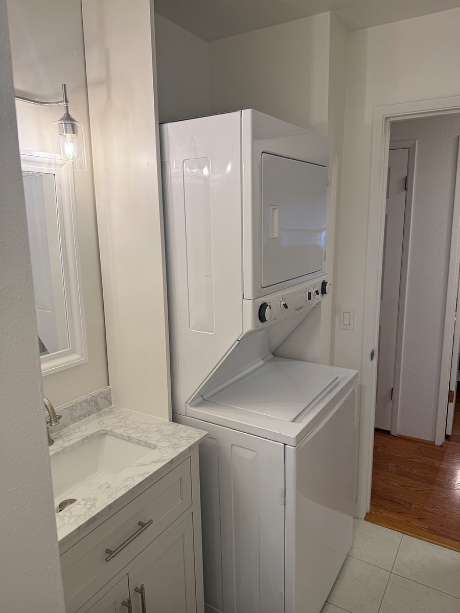 Hall bathroom has stackable washer and dryer