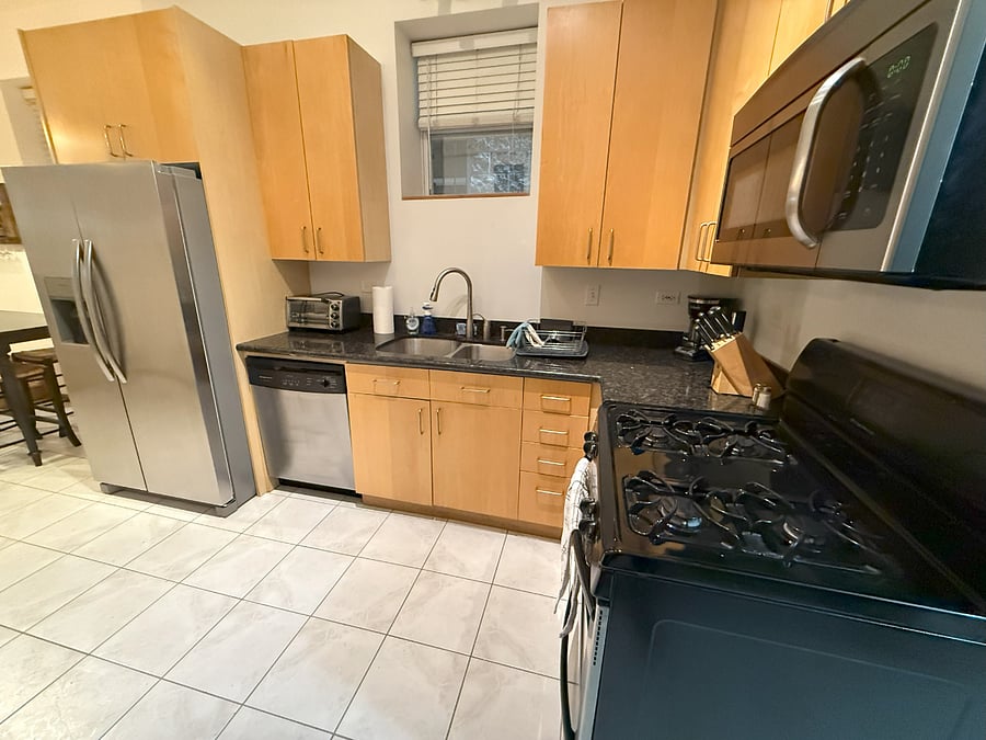 Stocked kitchen with brand new toaster oven, coffee maker, and fridge with water and ice dispenser.