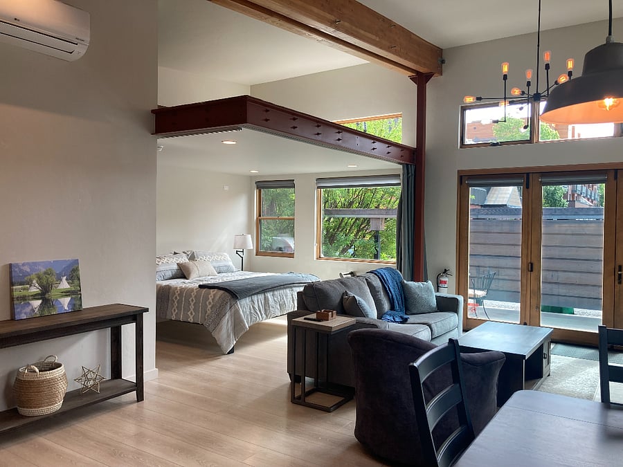 Bright, open-concept studio with natural light, vaulted ceilings, and a comfortable king bed