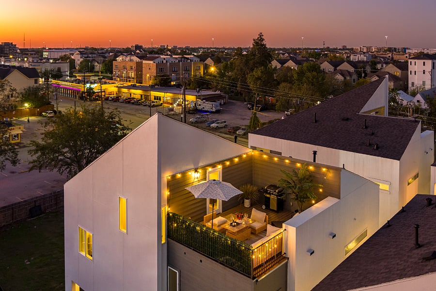 An aerial view of a house with a patio at dusk.