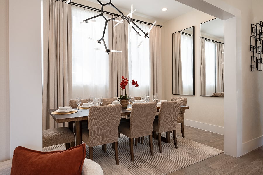 A dining room with a large table, chairs, and a chandelier.