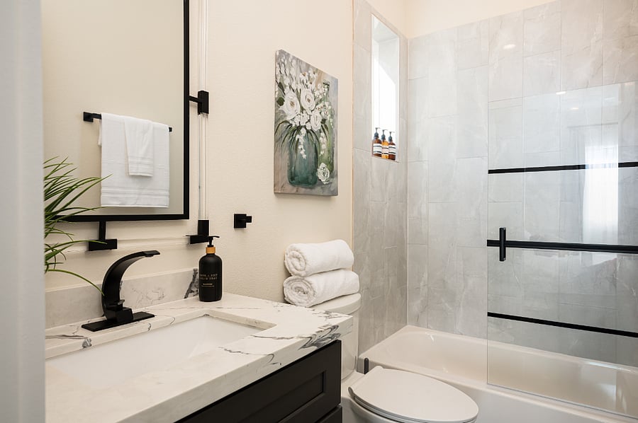 This bathroom features a freestanding tub, a marble countertop, and plush towels on the third floor