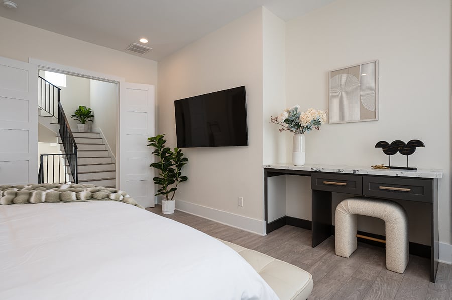 A king bedroom with a bed, a TV, and a desk.