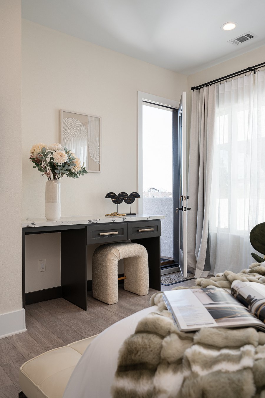 A modern vanity with a marble countertop and a unique designer stool. 