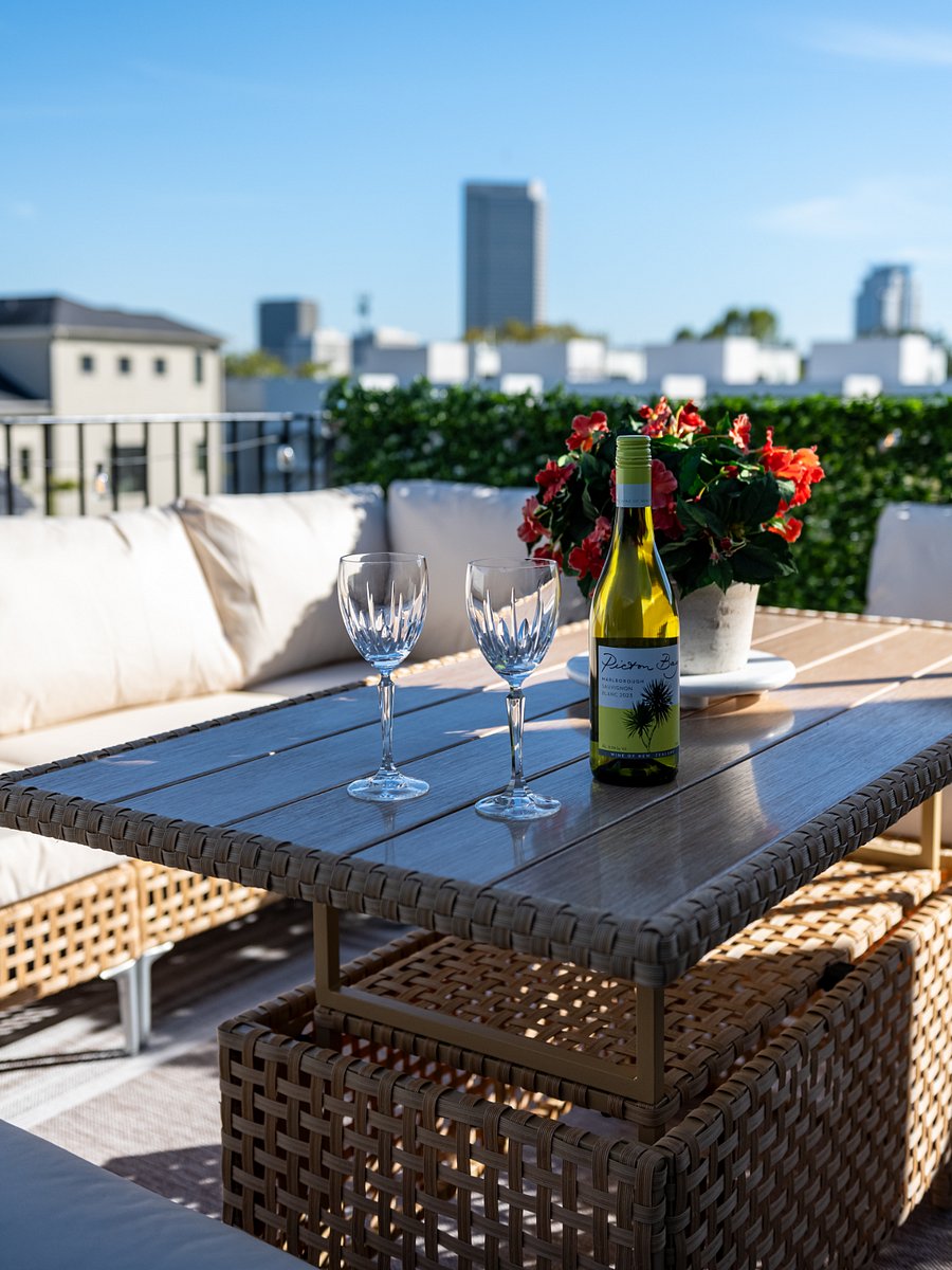 A rooftop patio with a table and chairs, perfect for enjoying a glass of wine.