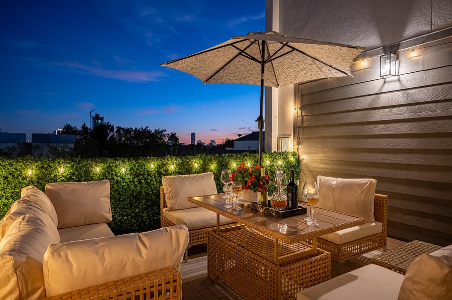 The rooftop deck has a comfortable seating area with a table and chairs, perfect for entertaining