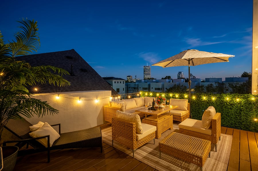 The rooftop deck is decorated with string lights, creating a cozy and romantic ambiance.