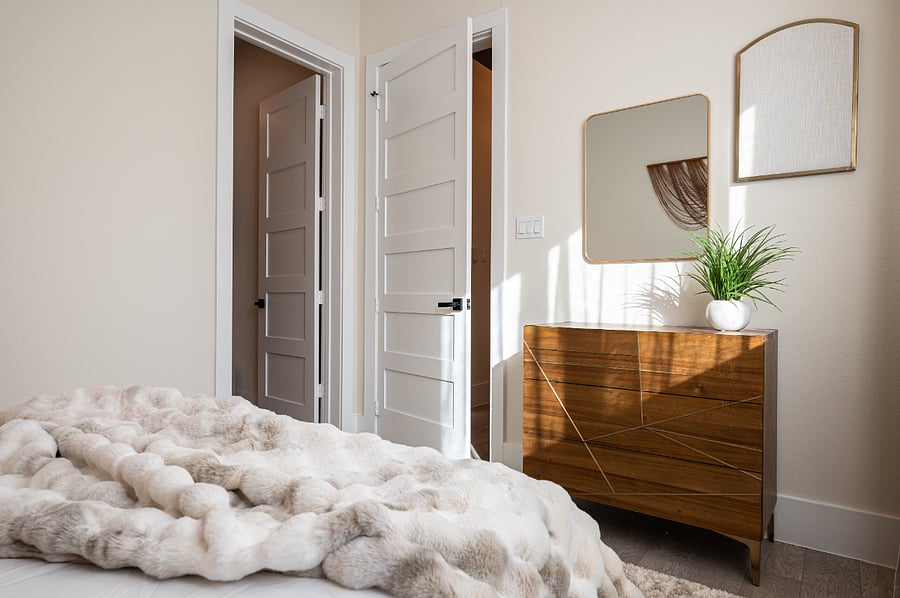 Enjoy the plush bedding, stylish furniture, and a lot of natural light in this luxurious bedroom.