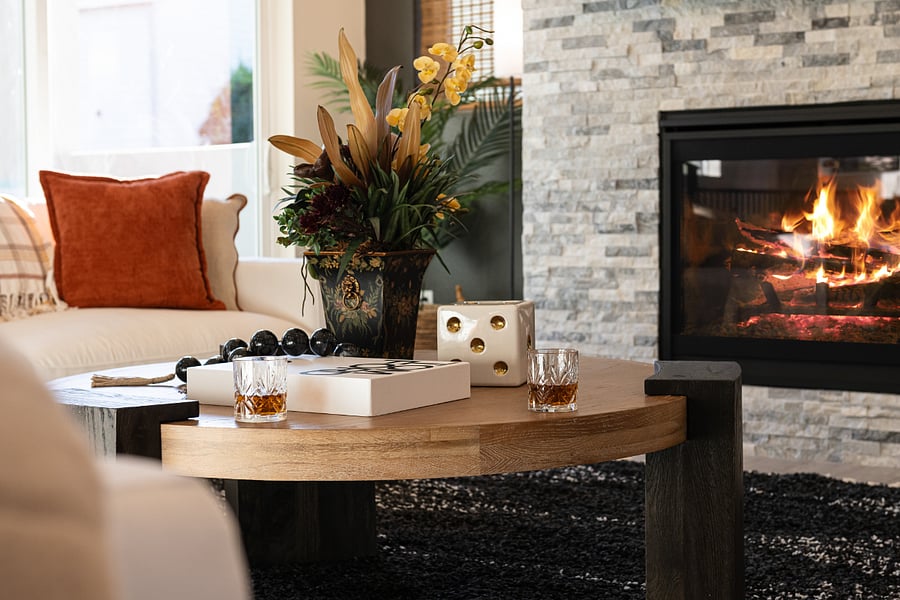 A living room with a fireplace, designer seating area and coffee table