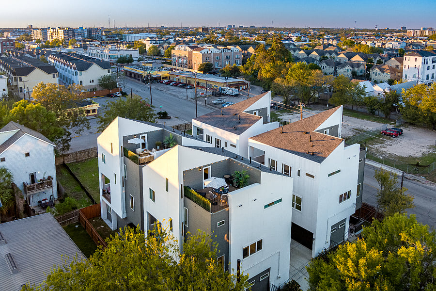 An aerial view of a modern house with a garage and a backyard.
