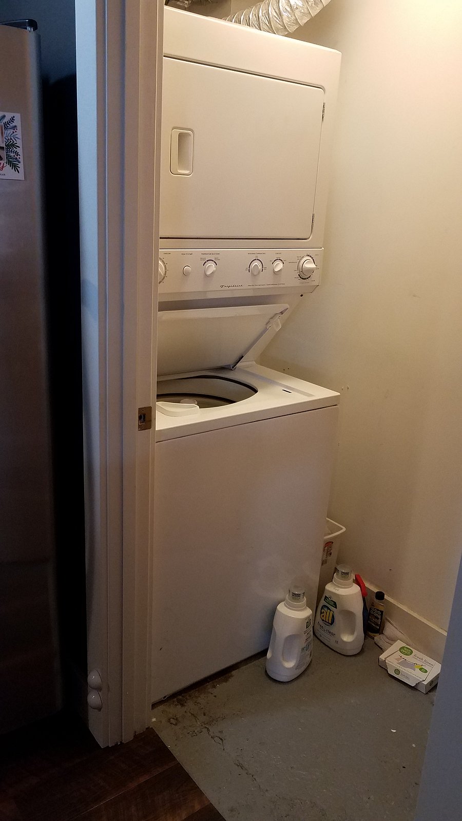 Stacked washer/dryer in unit.