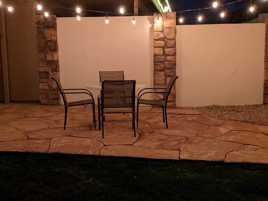 Backyard with table and chairs under the cafe lights