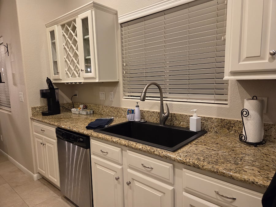 Kitchen window above the sink with view of the backyard