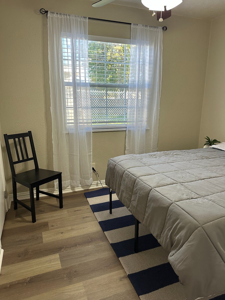 Bedroom with new blinds and ceiling fan.  Small closet/dresser.  This bedroom is directly across the hall from bathroom.