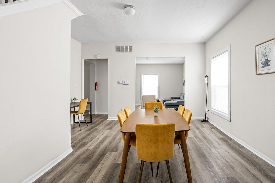 Bright and spacious dining area with modern mustard-yellow chairs.