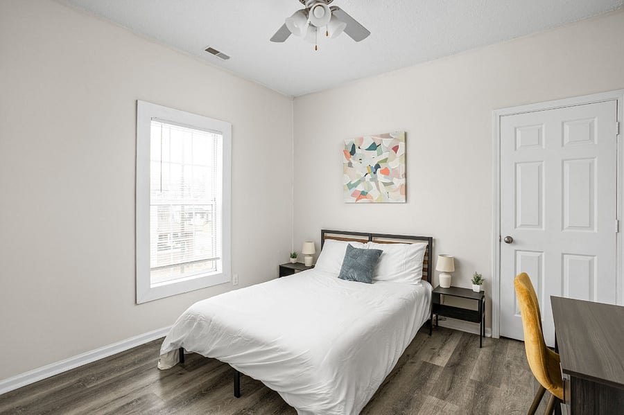 Bright and stylish bedroom with a minimalist design, featuring a cozy bed, modern decor, and a functional workspace.