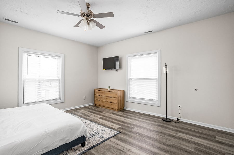 Spacious and bright bedroom with modern furnishings, large windows, and a minimalist aesthetic.