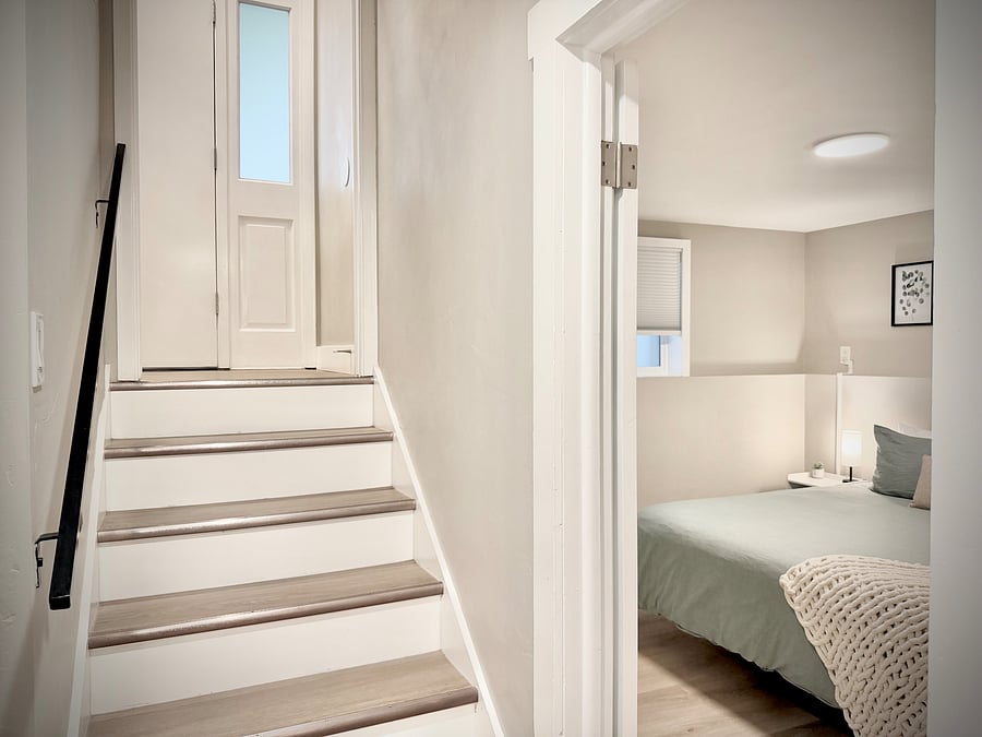 Split entry - stairs going to the front door landing with the downstairs bedroom with King Bed on the right.