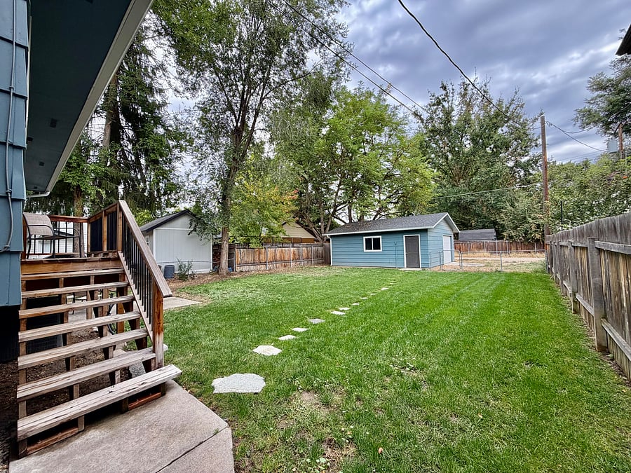 Fully Fenced Backyard, steps to upstairs backdoor and stepping stones to detached garage.