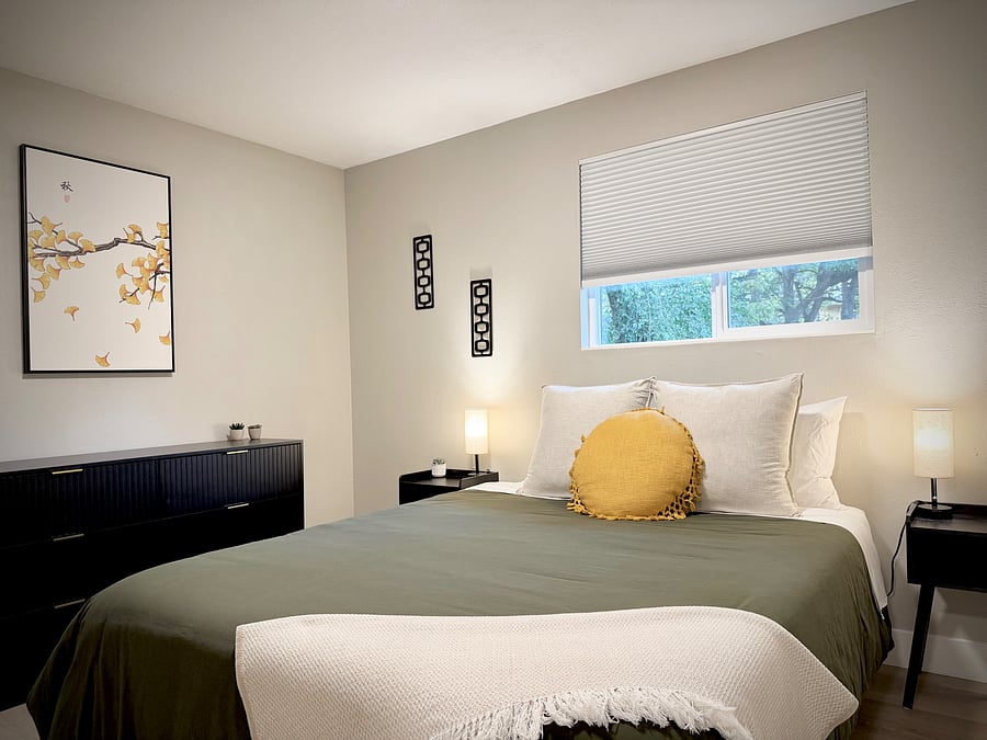 Queen Bed, dresser and blackout shades in an upstairs bedroom.