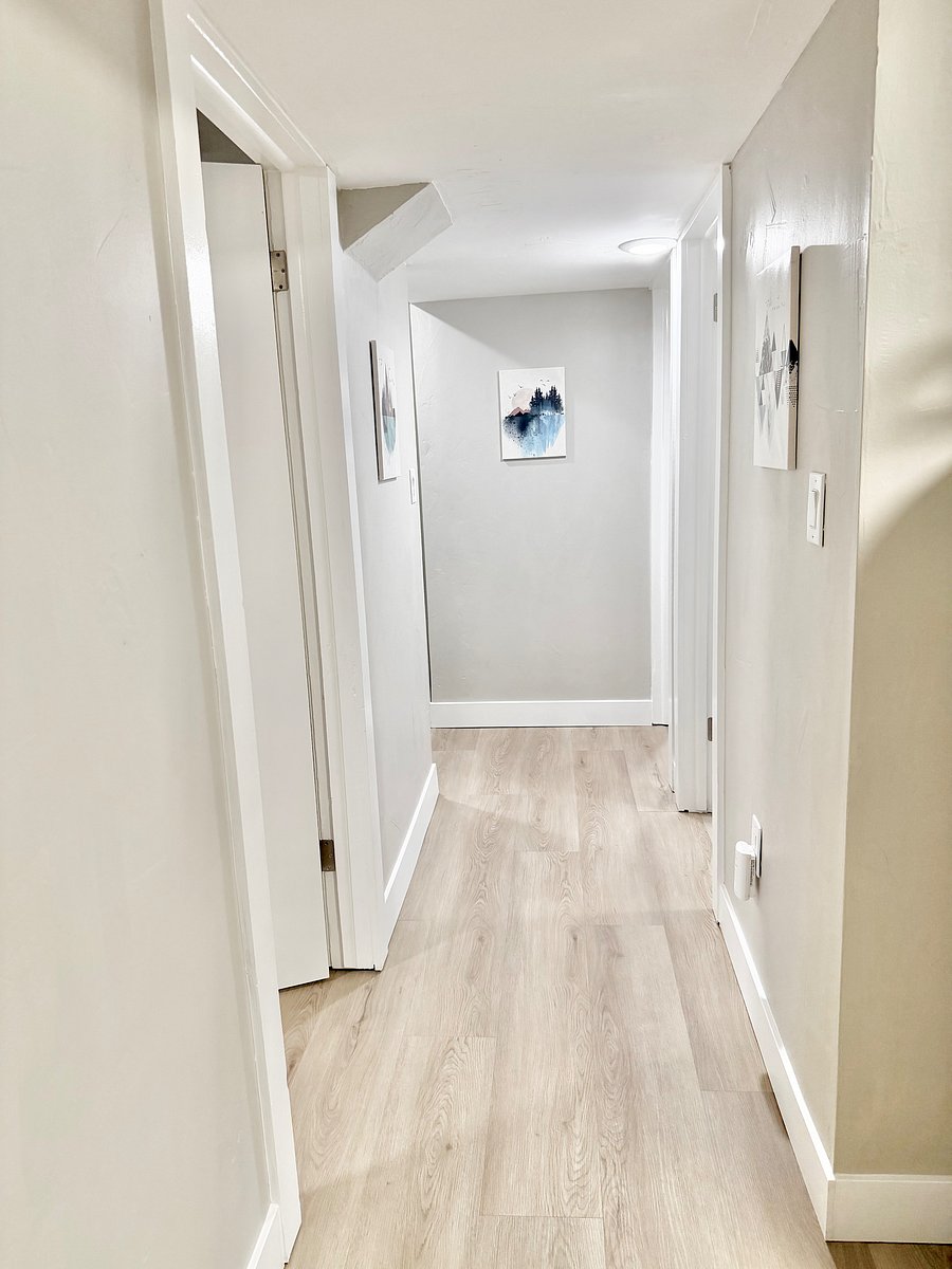 Down Stairs Hall with Yoga room on the left, bathroom on the right, office on the right and king bedroom on the left.