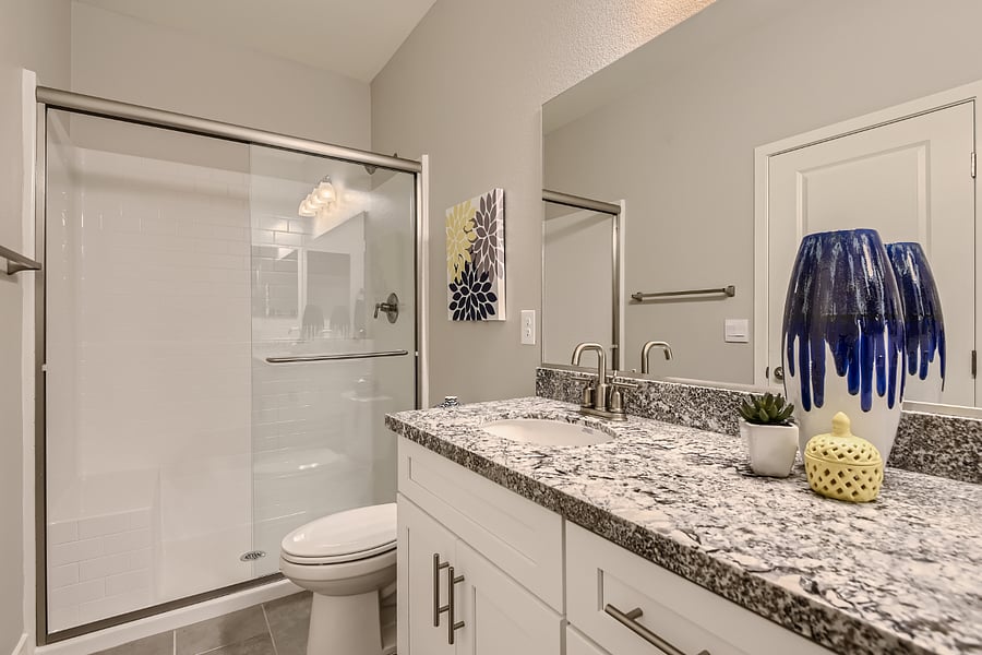 Large, step-in shower with glass sliding doors and seat.