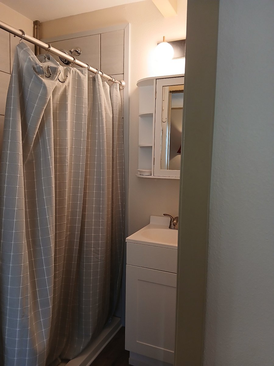 New bathroom with corner toilet and shower.
