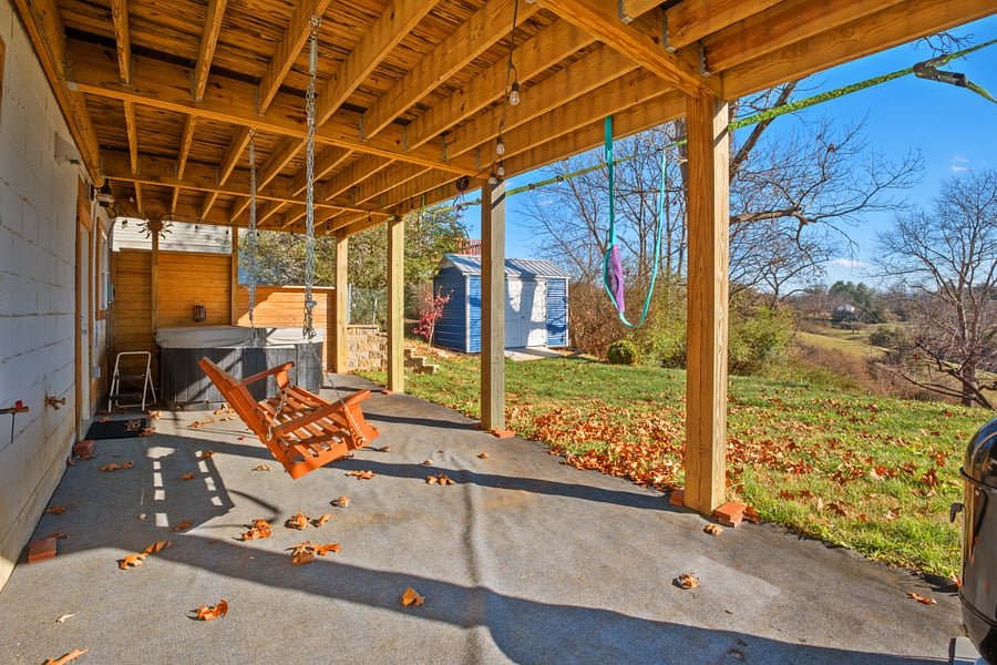 Patio with swing and hot tub. Storage shed