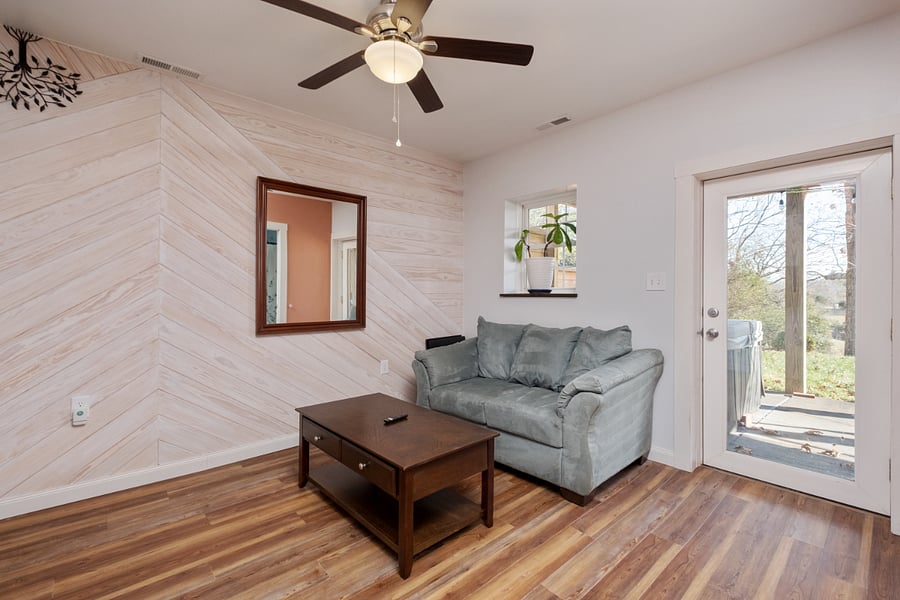 Living room with love seat. Lots of natural light