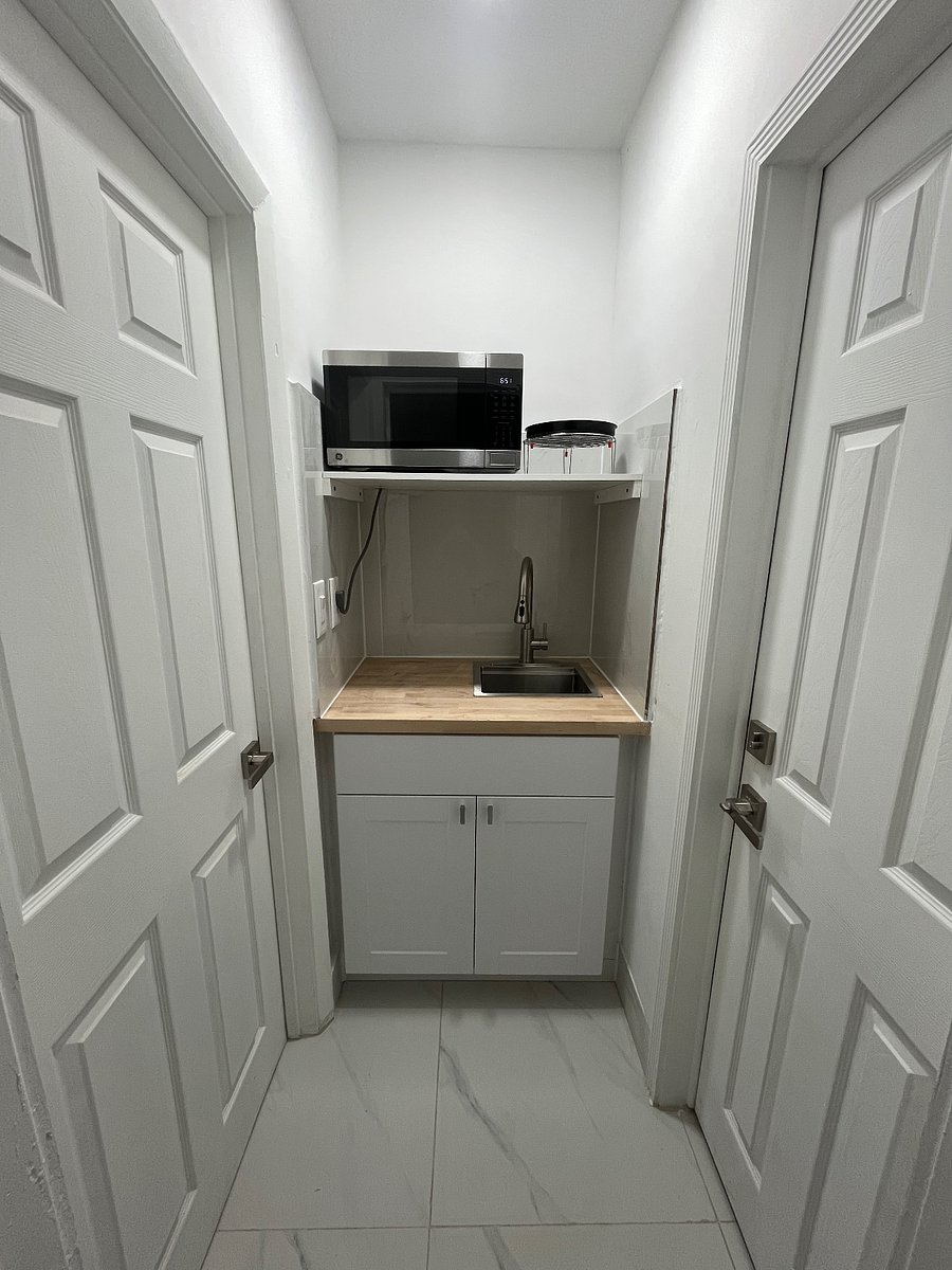 Mini kitchenette w/ sink, microwave/ air fryer all in 1, single burner cooktop, dishes, pots and pans. Efficient workspace and storage!