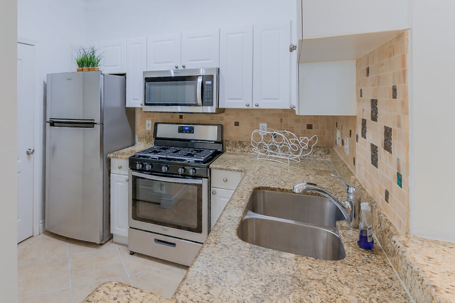 Kitchen picture - full fridge, microwave, oven, coffee maker, dishwasher, and fully stocked with dishes and cookware.