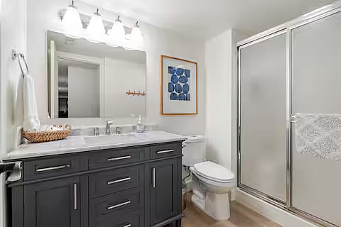 Bathroom with shower. Stocked with essentials including towels, soap, shampoo, conditioner, body wash and toilet paper.