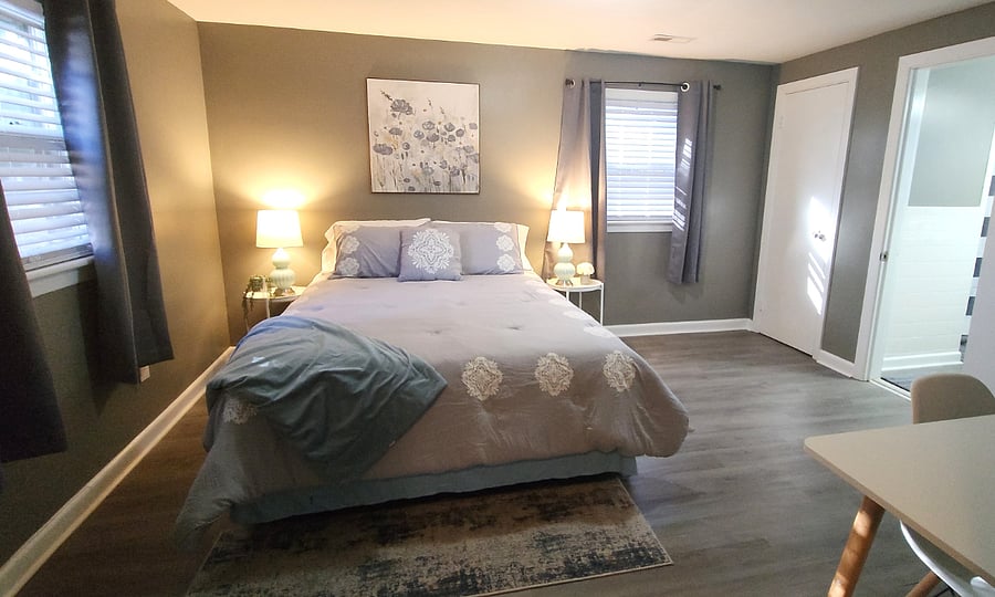 Bedroom with a full-sized bed, walk-in closet (not shown in picture), additional closet space, desk/writing table and attached bathroom